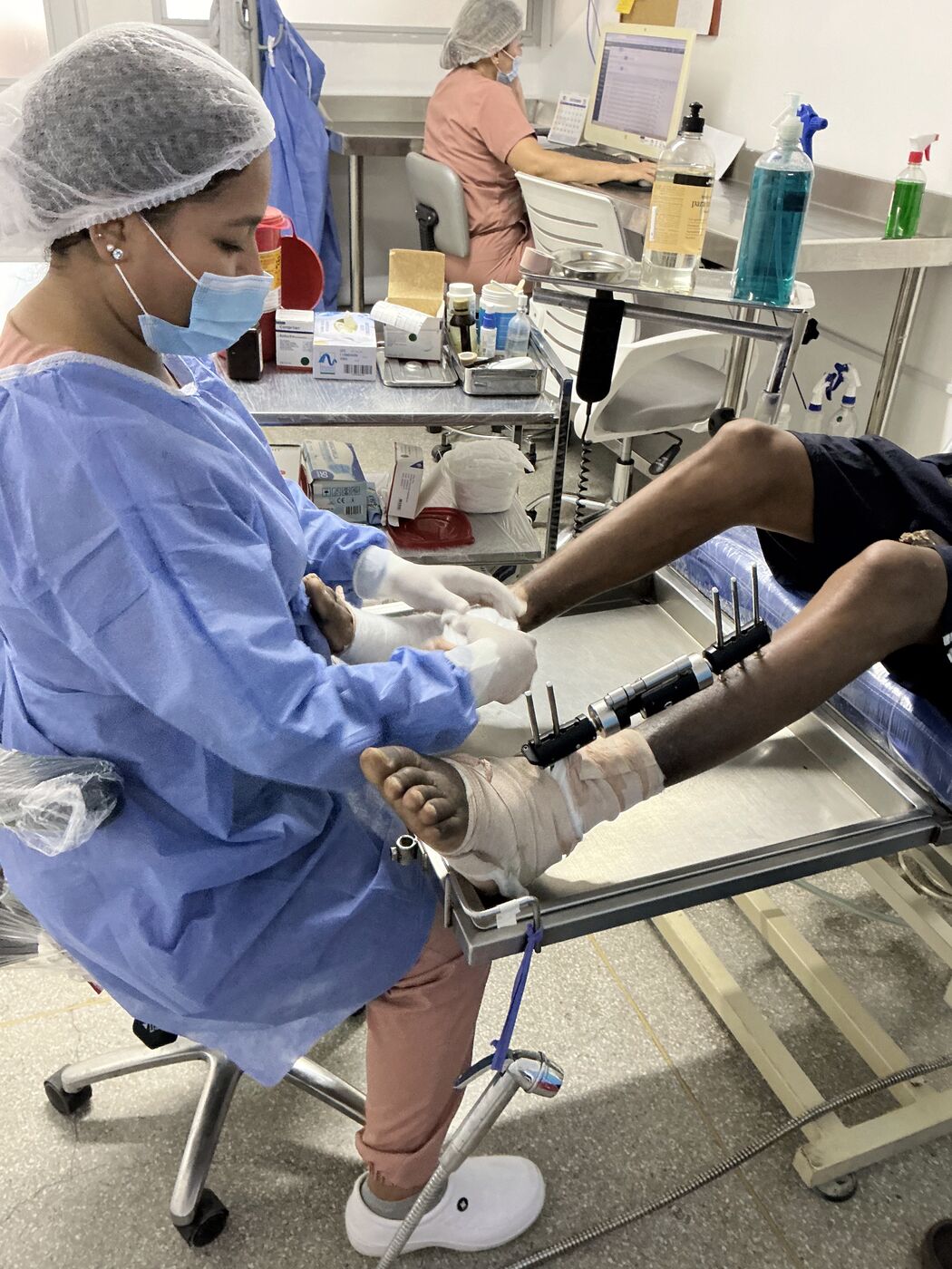 Enfermera especialista realizando curación de herida en extremidad inferior